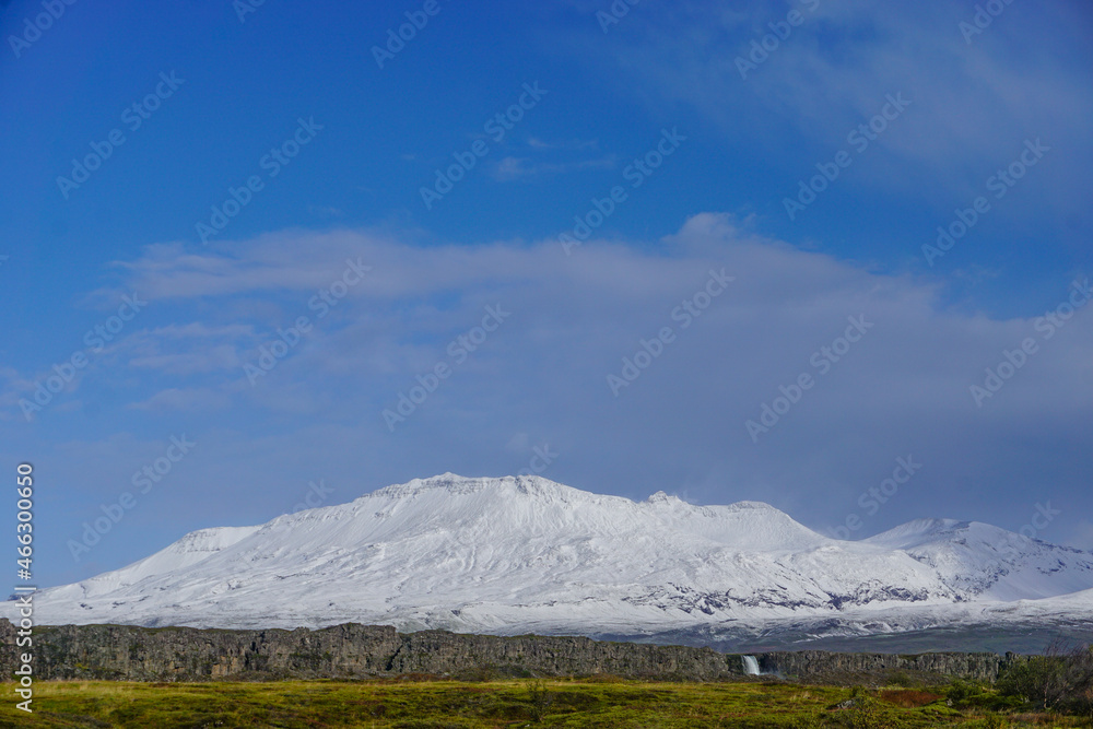 Thingvellir National Park, Iceland: Oxararfoss (waterfall) and snow-covered mountains in the distance.