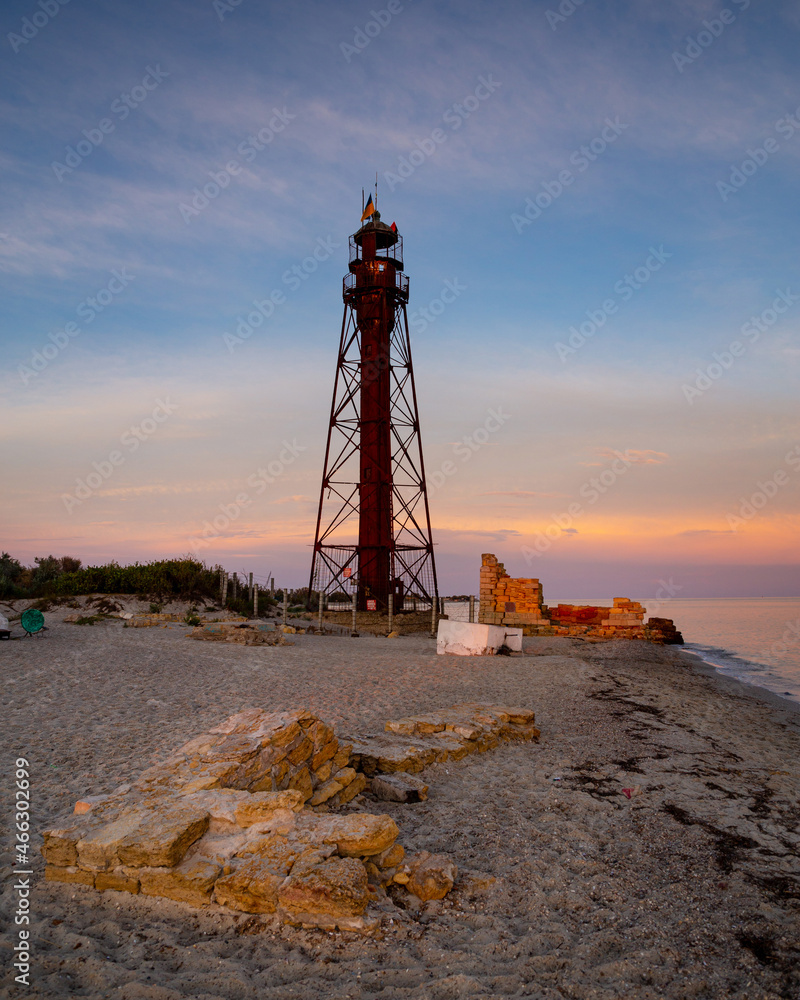 Sea lighthouse on the island of Dzharylhach at sunset.