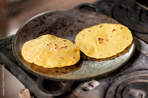 comal metálico muy caliente cocinando unas tortillas de maíz típicas de guanacaste costa rica, en una estufa de acero a la leña photo