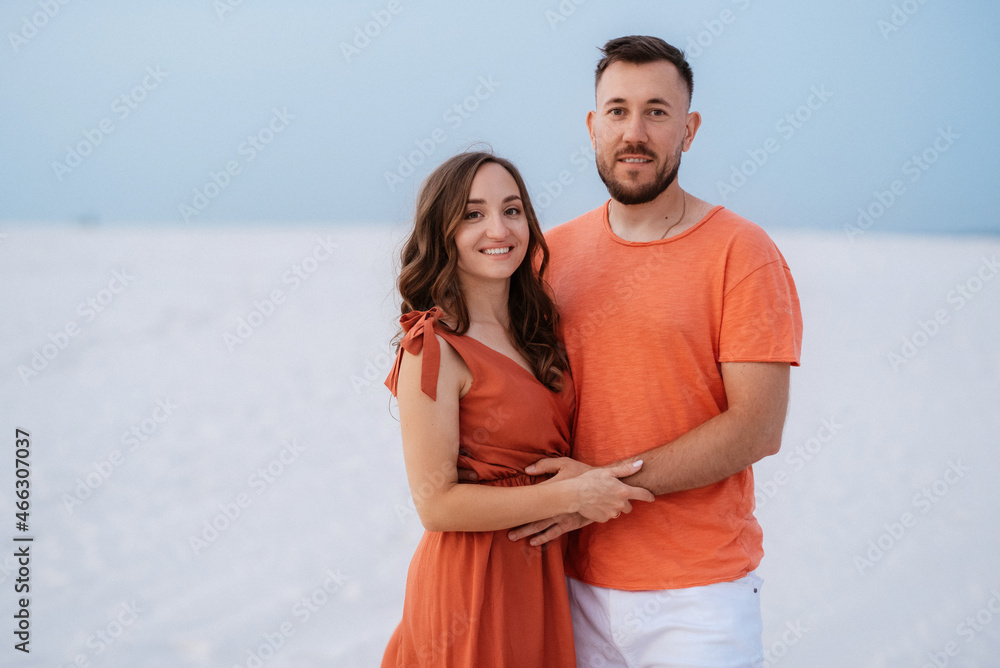 young couple in orange clothes with dog