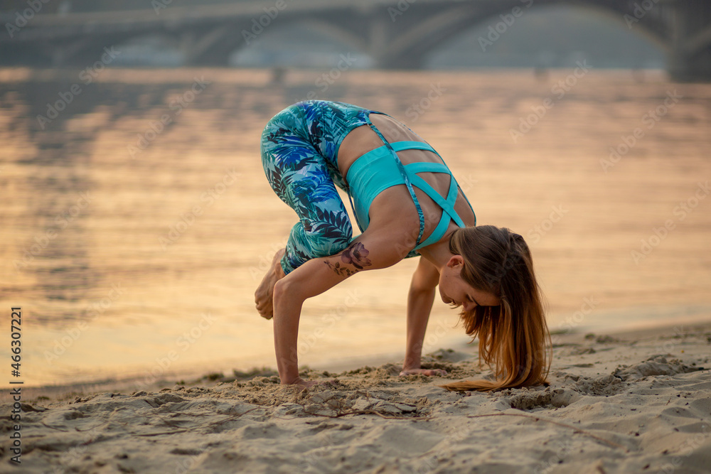 Naklejka premium yoga girl on the beach, backasana, sunset, balance, fitness, stretching and relaxation 