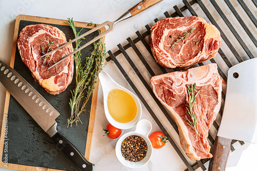 Obraz na płótnie three delicious steaks ready to grill on a white marble surface w salonie