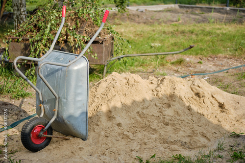 Cuadro en lienzo metal wheelbarrow with rubber wheel standing next a pile of sand