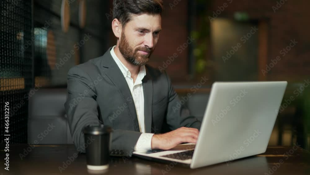 Successful Caucasian business man working during a break in hotel restaurant or cafe with indoors a modern dark background Handsome bearded businessman with laptop coffee cup. freelancer in cafeteria Successful Caucasian business man working during a break in hotel restaurant or cafe with indoors a modern dark background Handsome bearded businessman with laptop coffee cup. freelancer in cafeteria