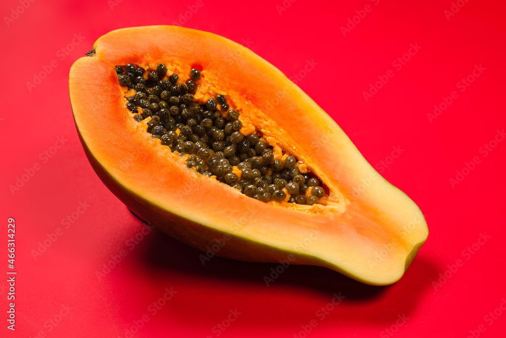 Papaya fruit on a orange background. Half papaya. Papaya fruit on a orange background. Half papaya.
