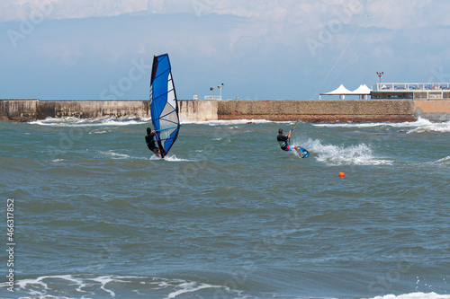 Kitesurfing and Windsurfing During a Windy Day with a Very Rough Sea