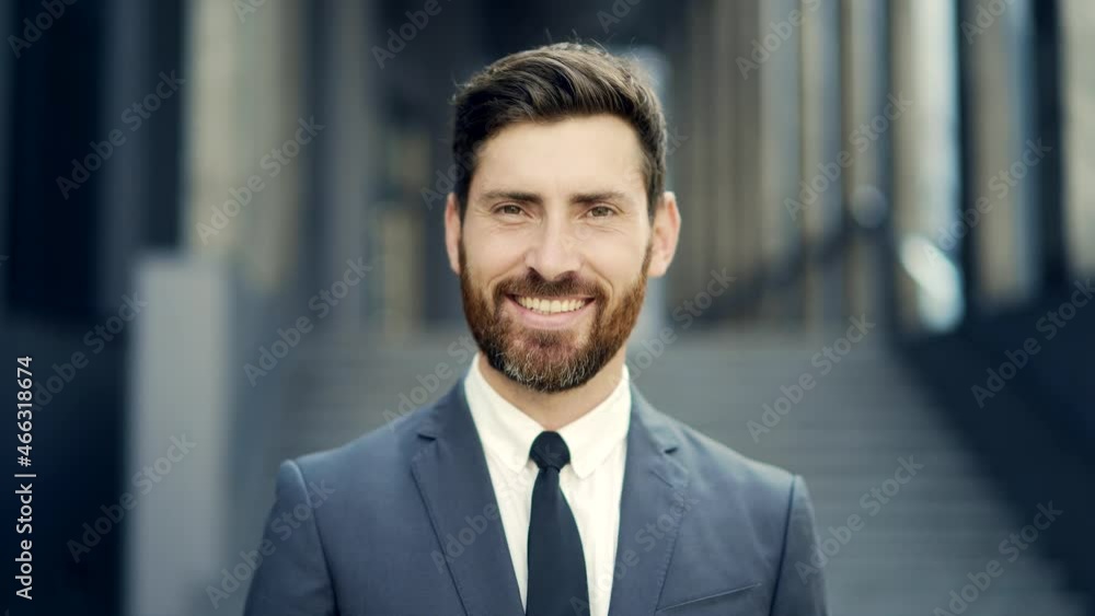 close up portrait happy Bearded Caucasian business man looking at camera outside. Face of smile handsome successful businessman in formal suit on modern urban city street background outdoor closeup close up portrait happy Bearded Caucasian business man looking at camera outside. Face of smile handsome successful businessman in formal suit on modern urban city street background outdoor closeup