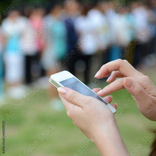 Close up of woman using mobile smart phone in the park.