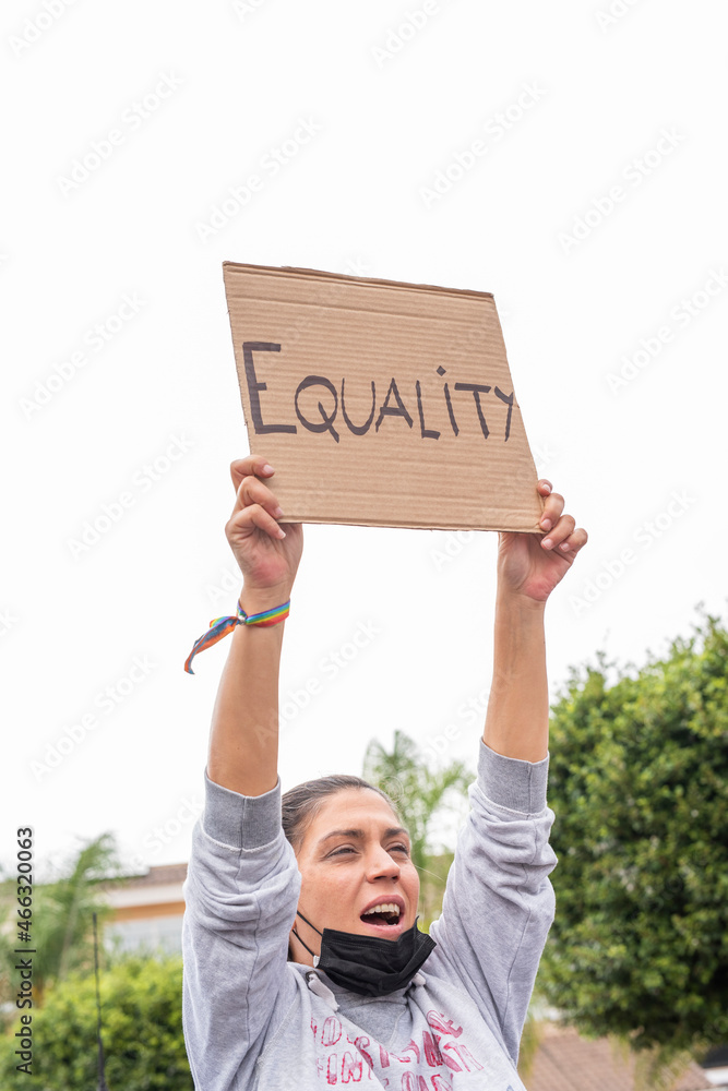 Young Caucasian girl chanting at a demonstration showing the equality sign. Concept of gender equality. Young Caucasian girl chanting at a demonstration showing the equality sign. Concept of gender equality.