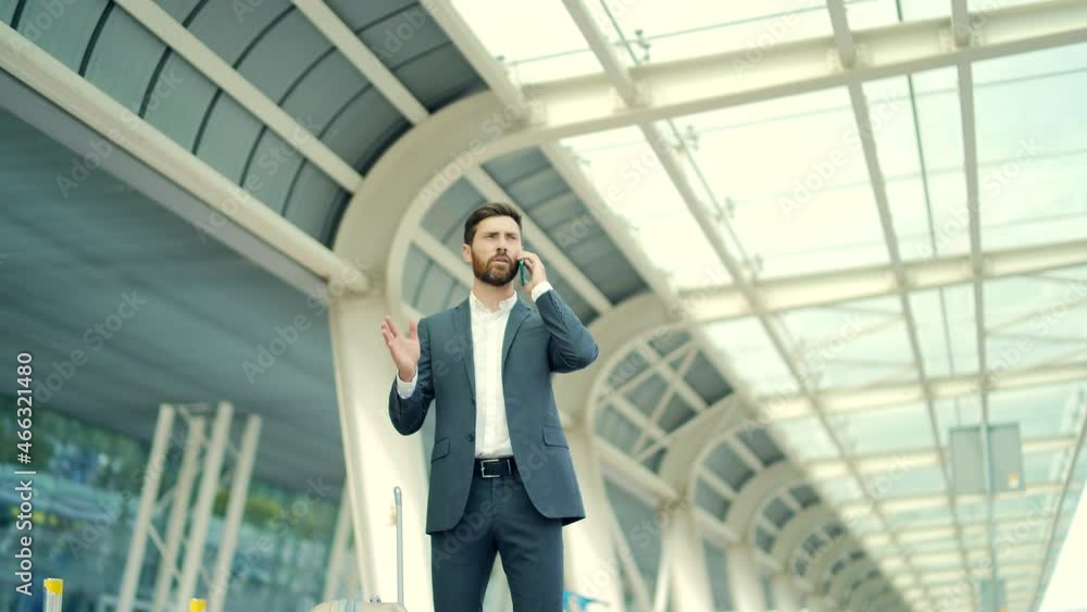 business man standing background a modern train station airport hotel or bus stop in formal suit with a suitcase speaks mobile phone Traveling businessman tourist talking and conversation smartphone business man standing background a modern train station airport hotel or bus stop in formal suit with a suitcase speaks mobile phone Traveling businessman tourist talking and conversation smartphone