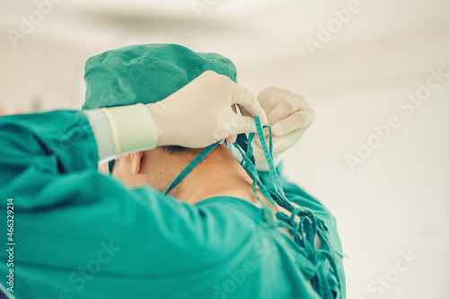 Surgeons are tying face masks and dressing caps in preparation for surgery. in the hospital dressing room