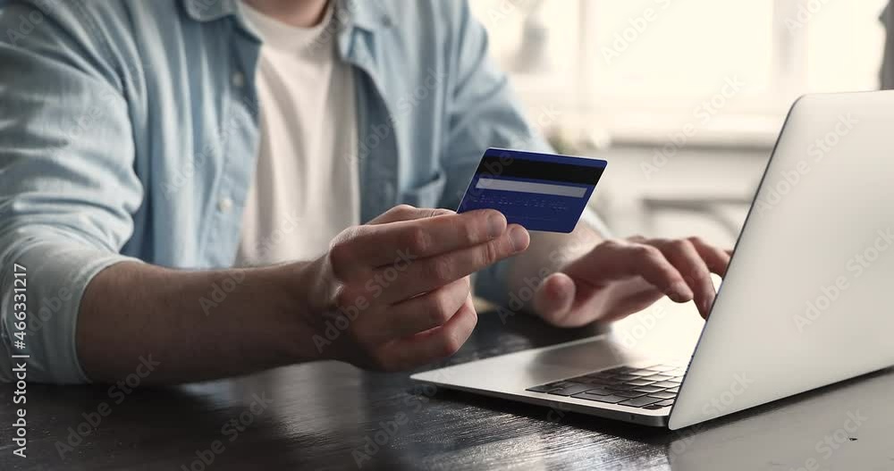 International money transfer, easy comfort e-services, secure payment to prevent scam and fraud, on-line shopping, ecommerce concept. Close up view man holds credit card buying goods using computer International money transfer, easy comfort e-services, secure payment to prevent scam and fraud, on-line shopping, ecommerce concept. Close up view man holds credit card buying goods using computer