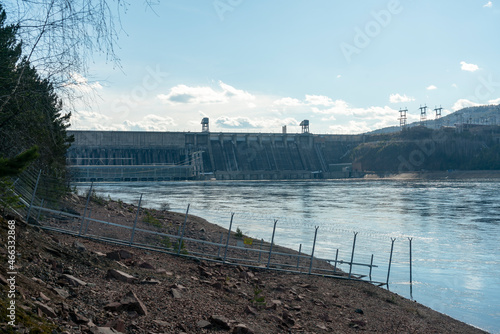 Rocky river bank against the background of the hydroelectric power station. photo