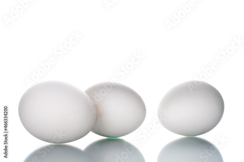 Three white chicken eggs, close-up, isolated on white.