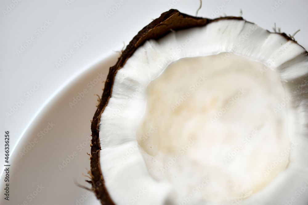 A broken slice of coconut on a plate A broken slice of coconut on a plate