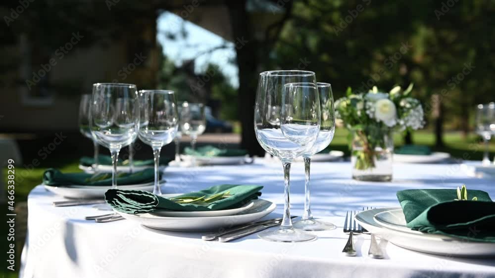 Outdoor banquet table set up served dinner tableware and silverware. Wide footage. Outdoor banquet table set up served dinner tableware and silverware. Wide footage.