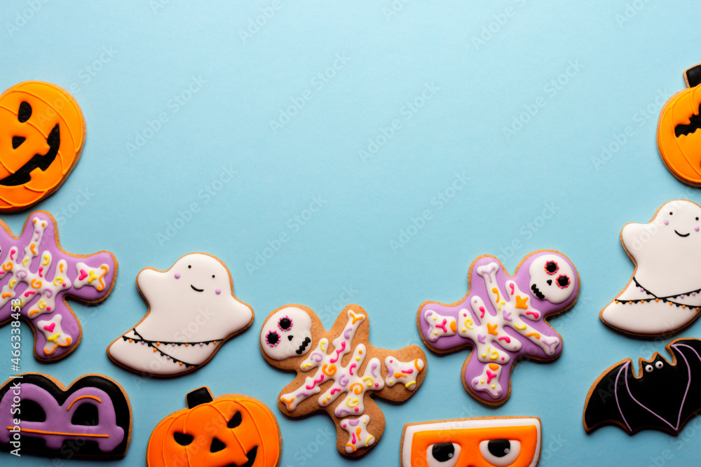 Fototapeta premium Homemade Halloween cookies, pumpkins, ghosts, bats , sekeletons on blue background