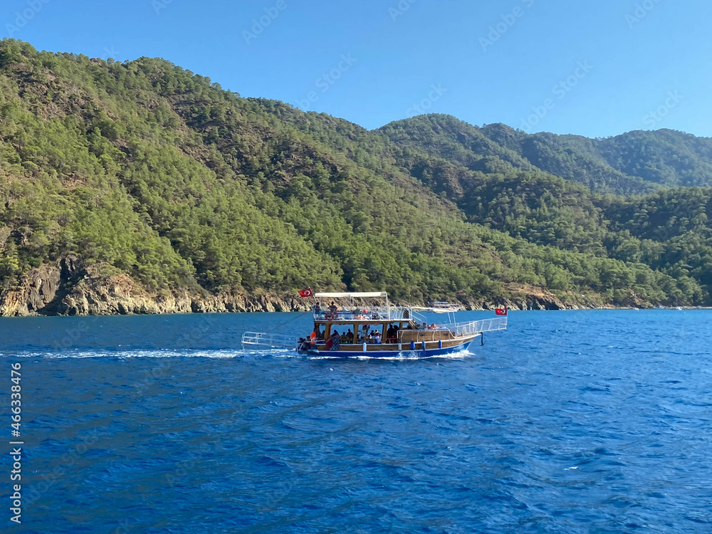 Beautiful tourist ship, cruise yacht on the background of the blue sea with water and mountains in a tropical southern country