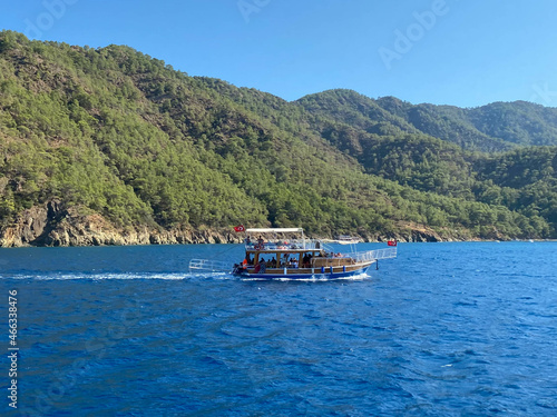 Beautiful tourist ship, cruise yacht on the background of the blue sea with water and mountains in a tropical southern country