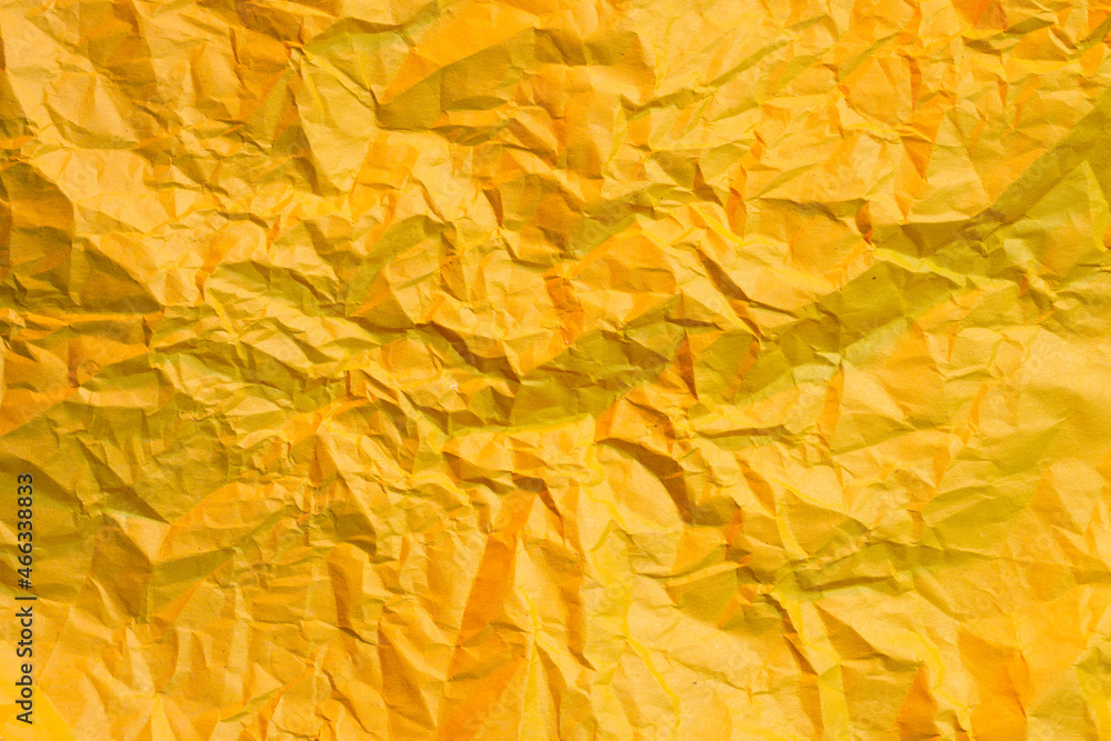 Photo of crumpled wrinkled yellow office paper lit with red light, background texture Photo of crumpled wrinkled yellow office paper lit with red light, background texture