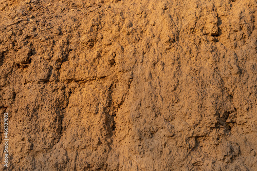 Limestone and clay cliff surface of yellow-orange color. Background texture.