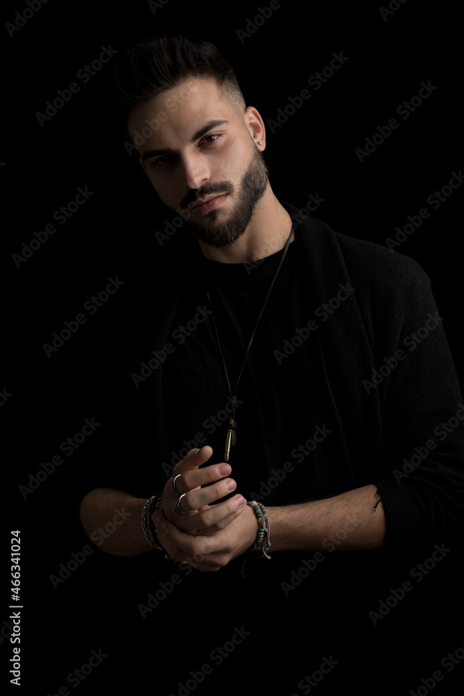© Viorel Sima - sexy bearded man touching hands on black background in studio