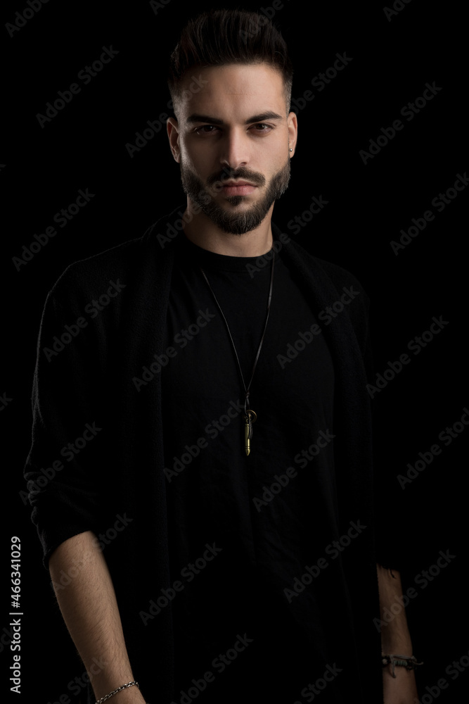 Naklejka premium confident casual fashion model with beard posing on black background