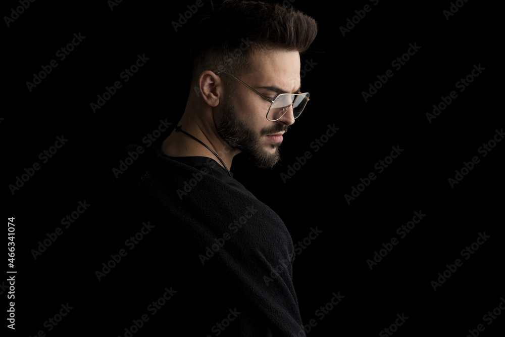 side view of mysterious young man wearing glasses and looking down side view of mysterious young man wearing glasses and looking down