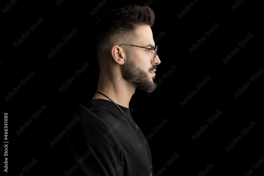side view of bearded sexy young man wearing glasses and looking to side