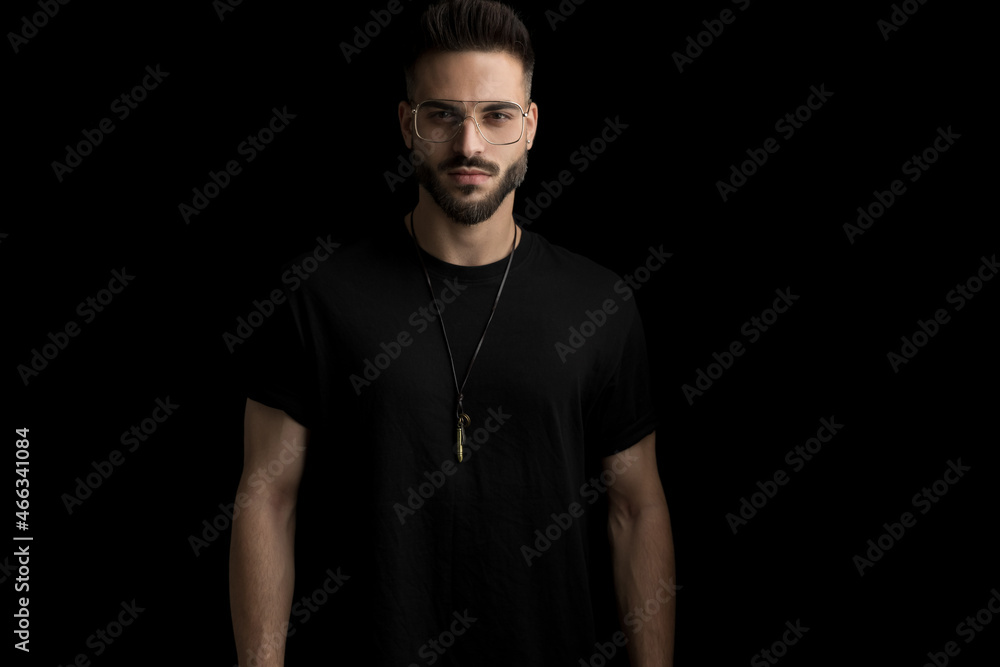 Obraz premium cool mysterious man wearing glasses and posing in studio