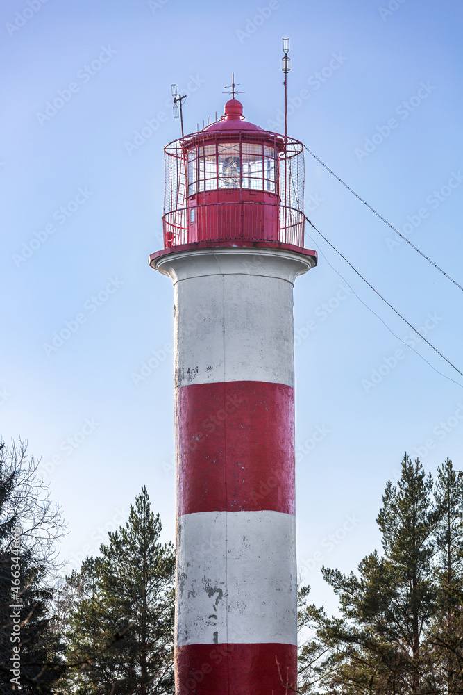 A tower-type lighthouse on the seashore against the blue sky