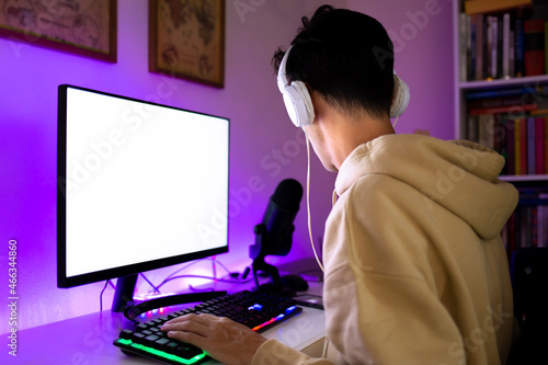 Young man playing multiplayer online games on computer.