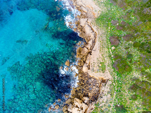 Green plants, rocks and blue sea in Alghero shore seen from above