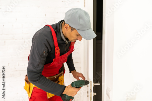 Young man fixing the door with screwdriver