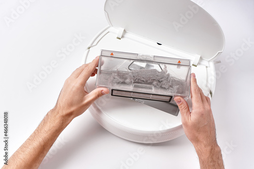 Take out the transparent dust container from the robot vacuum cleaner after cleaning the house. The container is completely clogged with dust photo
