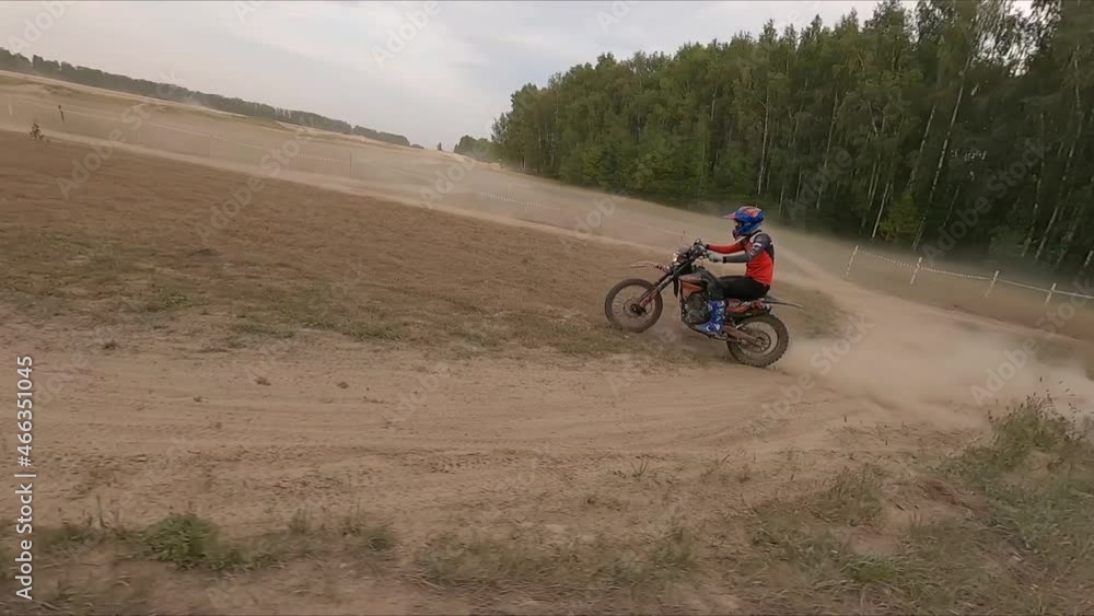 Person in helmet rides fast sportive motorcycle leaving dust trail along rural road at extreme competition aerial view Person in helmet rides fast sportive motorcycle leaving dust trail along rural road at extreme competition aerial view