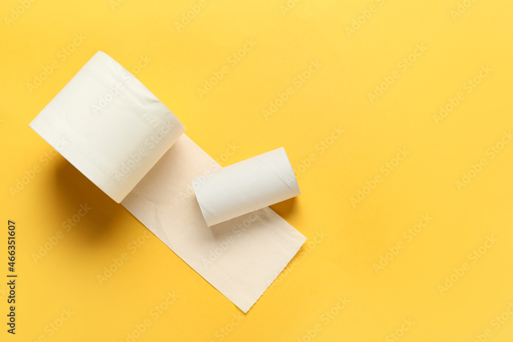 Roll of toilet paper and empty cardboard tube on yellow background Roll of toilet paper and empty cardboard tube on yellow background