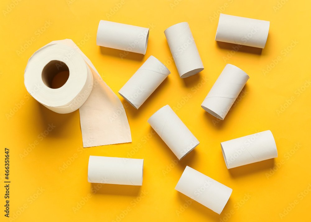Roll of toilet paper and empty cardboard tubes on yellow background Roll of toilet paper and empty cardboard tubes on yellow background