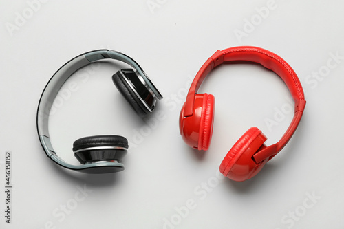 Different modern headphones on grey background