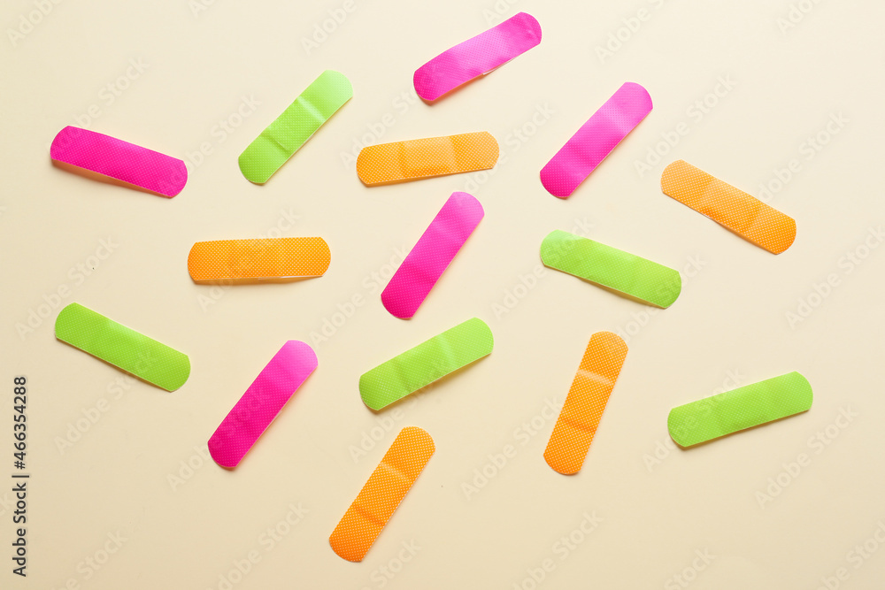 Different medical plasters on color background