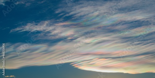 Thin wispy clouds creating rainbow patterns of scattered sunlight. Optical phenomenon on cirrostratus clouds. photo