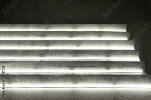 Iluminated concrete stairs of a ladder. Abstract cement ladder glowing