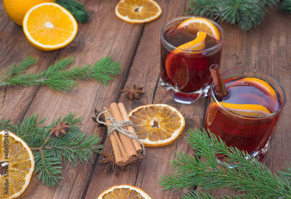 Christmas mulled red wine with spices and fruits on a wooden rustic table. Traditional hot drink at Christmas time Christmas mulled red wine with spices and fruits on a wooden rustic table. Traditional hot drink at Christmas time