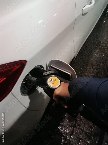 Diesel Benzina - Automobilista fa il pieno di carburante alla sua Auto - Verticale photo