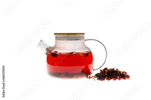 Red berry tea in a modern glass teapot isolated on a white background with tea nearby