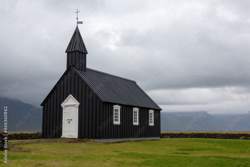 Budir Church in the Snaefelsness Peninsula area of Iceland. Black and white church in dramatic setting. Copy space in sky.