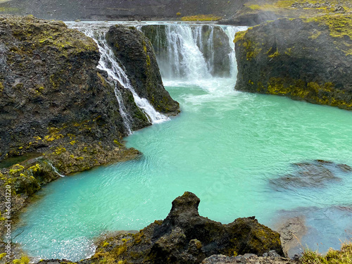 Multi-tiered waterfall in Iceland with sky blue color.