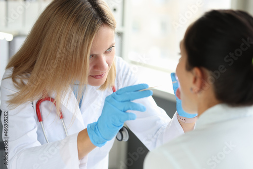 Doctor conducts physical examination of patient throat closeup