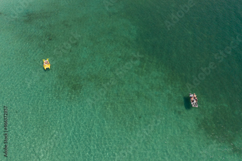 Aerial shot of floating sea bicycles on turquoise sea in Greece