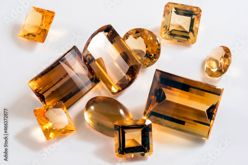 Several yellow citrine stones with different types of cutting in white background